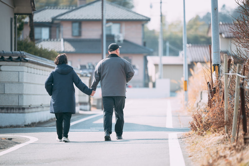 夫婦で手を繋いで歩いている画像